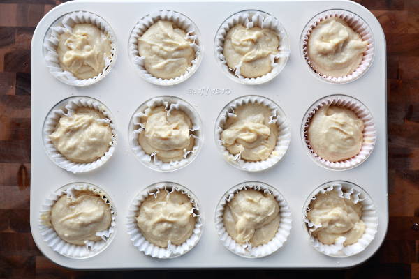 Spoon the batter into the muffin cups for the classic yellow cupcakes.