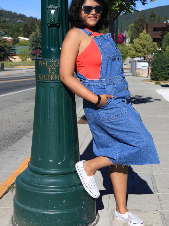 Wearing blue denim overall dress with red top and white sneakers for the 4th of July weekend in Whitefish.