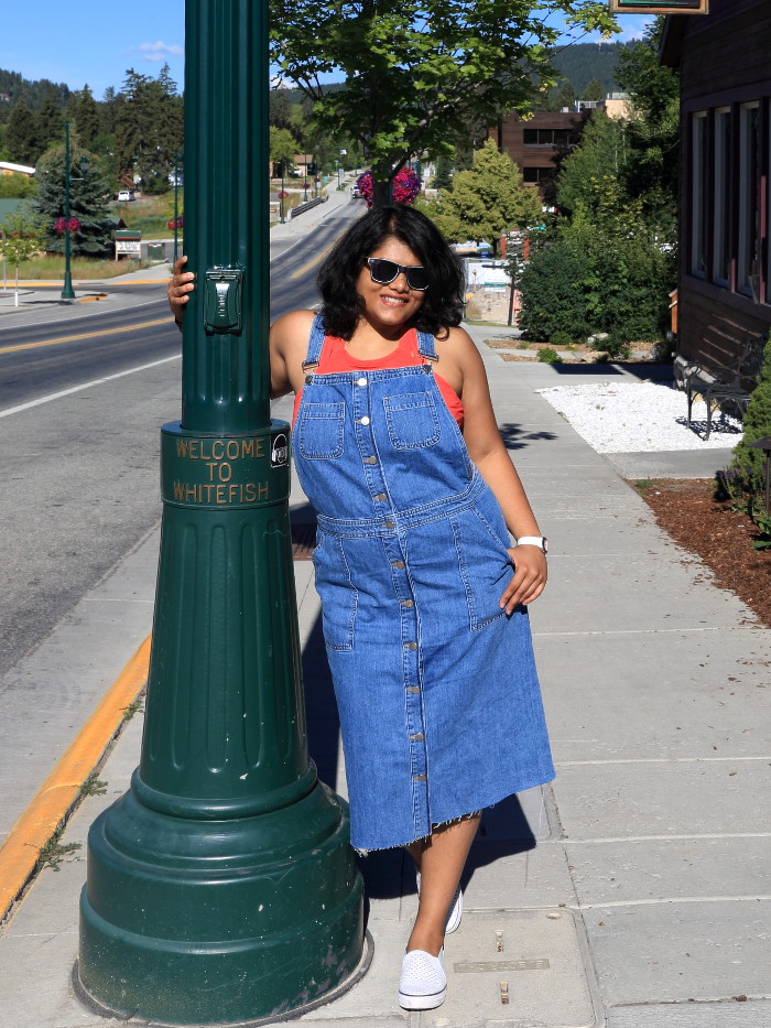 Wearing blue denim overall dress with red top and white sneakers for the 4th of July weekend in Whitefish.