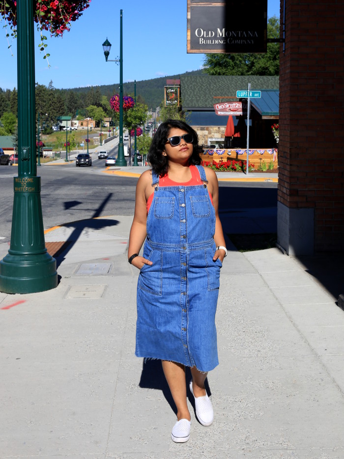 Wearing blue denim overall dress with red top and white sneakers for the 4th of July weekend in Whitefish.